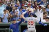 Chicago Cubs manager Craig Counsell, left, greets Michael Busch (29) after he scored a run on a sacrifice fly hit by Dansby Swanson against Washington Nationals pitcher Trevor Williams during the second inning of a baseball game in Washington, Tuesday, June 3, 2025. (AP Photo/Terrance Williams)