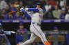 New York Mets pinch-hitter Francisco Lindor follows through on a double to drive in two runs off Colorado Rockies relief pitcher Zach Agnos in the ninth inning of a baseball game Friday, June 6, 2025, in Denver. (AP Photo/David Zalubowski)