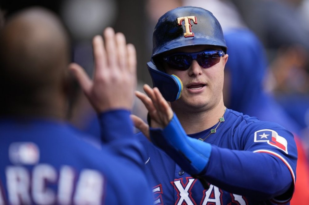 Texas Rangers designated hitter Joc Pederson (4) celebrates after scoring on a sacrifice fly from Marcus Semien (2) during the fourth inning of a baseball game against the Chicago White Sox, Saturday, May 24, 2025, in Chicago. (AP Photo/Erin Hooley)