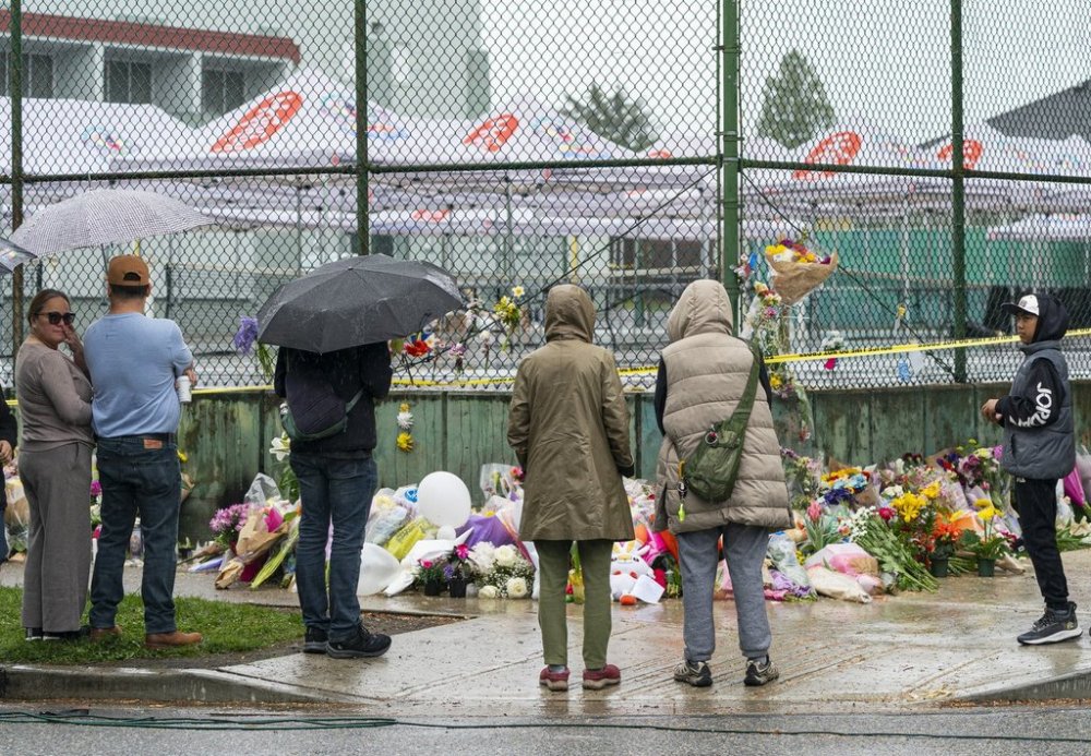 Members of the Filipino community gather at a memorial site on April 28 for the victims of an incident where a car drove through a crowd killing multiple people in Vancouver on April 26. THE CANADIAN PRESS/Rich Lam