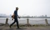 A man walks along the St. Lawrence River in front of the Old Port of Montreal on Friday, June 6, 2025. Smoke from the wildfires in the Canadian Prairies is causing poor air quality and reduced visibility in the Greater Montreal region. THE CANADIAN PRESS/Christinne Muschi
