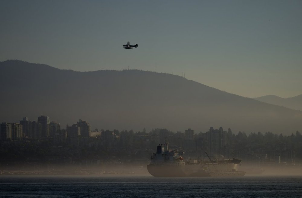 A Harbour Air seaplane takes off past the Seaways Athens oil tanker as a marine layer hangs over Burrard Inlet, in Vancouver, on Wednesday, Sept. 4, 2024. THE CANADIAN PRESS/Darryl Dyck