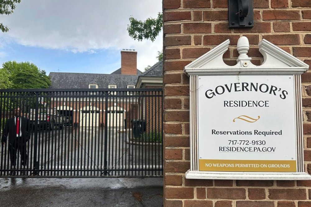 A member of Pennsylvania Gov. Josh Shapiro's state police protective detail stands on duty behind an entrance at the governor's official residence in Harrisburg, Pa., Tuesday, May 6, 2025. (AP Photo/Mark Scolforo)