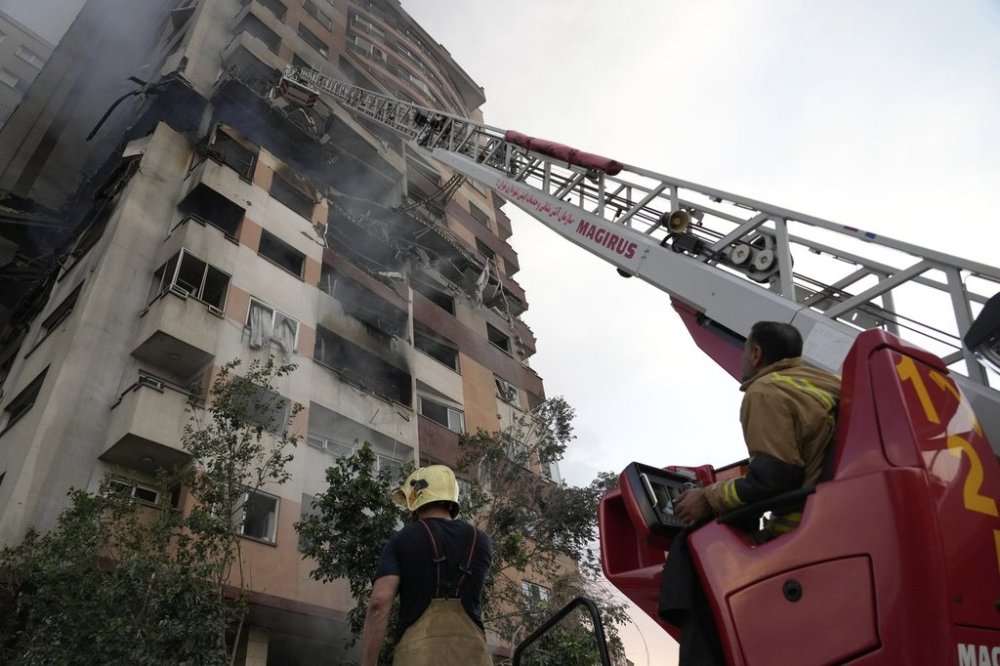 Firefighters work the scene of an explosion at a residence compound in northern Tehran, Iran, Friday, June 13, 2025. (AP Photo/Vahid Salemi)