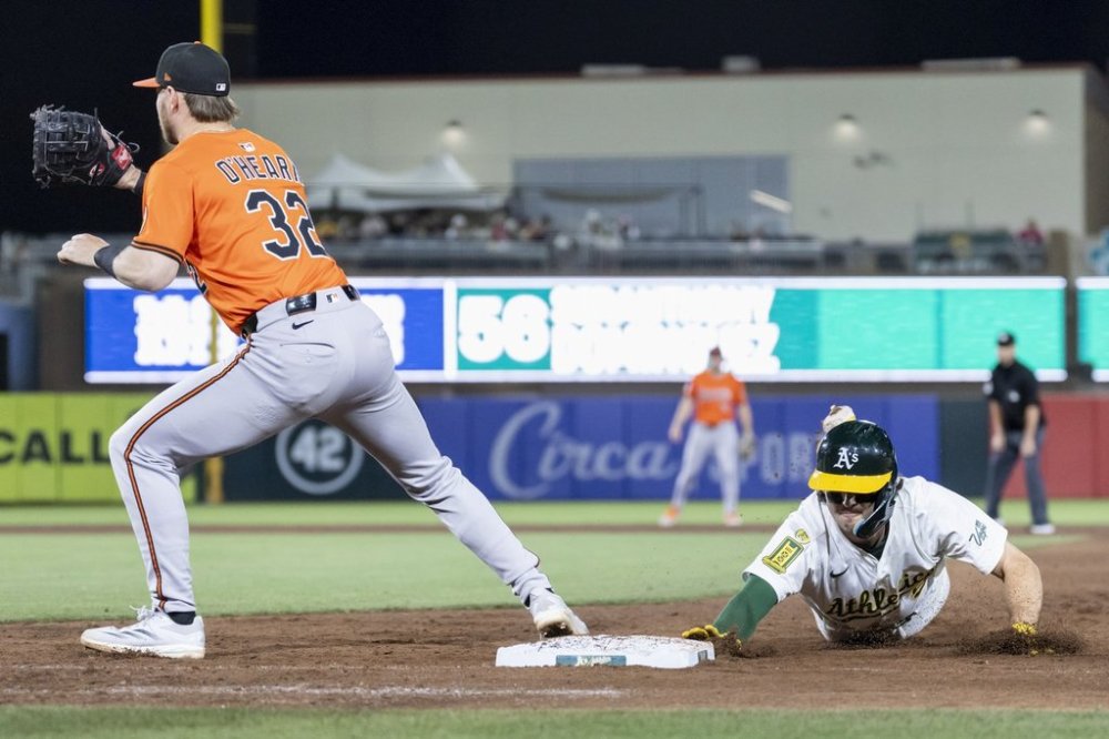 Baltimore Orioles first baseman Ryan O'Hearn (32) attempts to tag out Athletics' Jacob Wilson during the sixth inning of a baseball game Saturday, June 7, 2025, in West Sacramento, Calif. (AP Photo/Sara Nevis)