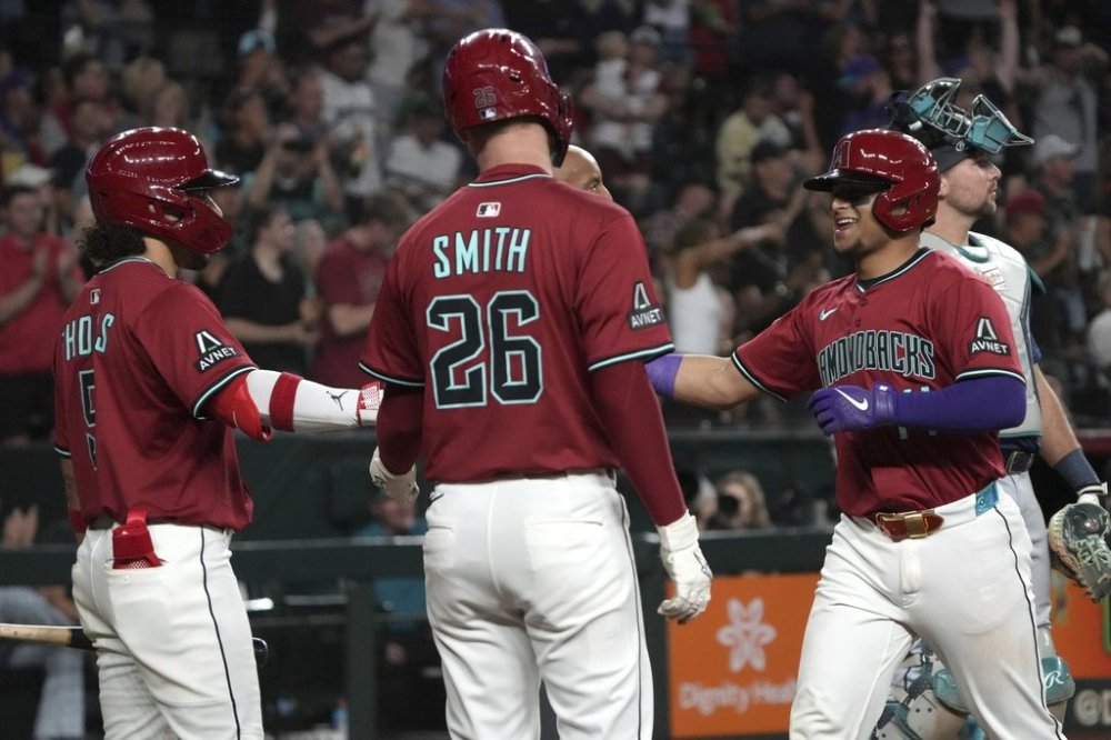 Arizona Diamondbacks' Gabriel Moreno celebrates with Alek Thomas (5) and Pavin Smith (26) after hitting a three run home run against the Seattle Mariners in the sixth inning during a baseball game, Tuesday, June 10, 2025, in Phoenix. (AP Photo/Rick Scuteri)