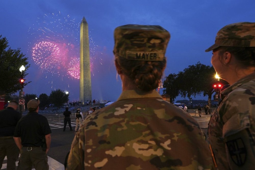 U.S. Army 2nd Lt. Hayle Mayer, left, and Corporal Addison Merrell, watch fireworks at the Washington Monument while attending a military parade commemorating the Army's 250th anniversary and coinciding with President Donald Trump's 79th birthday, Saturday, June 14, 2025, in Washington. (AP Photo/Jacquelyn Martin)