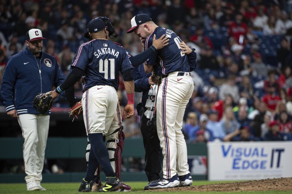 Cleveland Guardians relief pitcher Andrew Walters, right, holds his arm after an injury as Carlos Santana (41) and manager Stephan Vogt, left, look on during the ninth inning of a baseball game against the Los Angeles Angels, Friday, May 30, 2025, in Cleveland. (AP Photo/Phil Long)