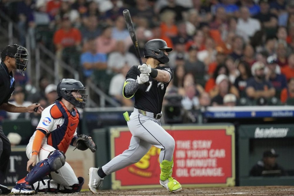 Chicago White Sox's Edgar Quero (7) hits a two-run single as Houston Astros catcher Victor Caratini watches during the third inning of a baseball game Tuesday, June 10, 2025, in Houston. (AP Photo/David J. Phillip)