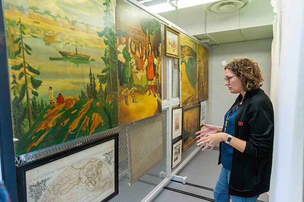 HBC MUSEUM COLLECTION / MANITOBA MUSEUM 
Amelia Fay, Curator of Anthropology and the HBC Museum Collection at the Manitoba Museum, shows paintings that would have been on display in stores.
