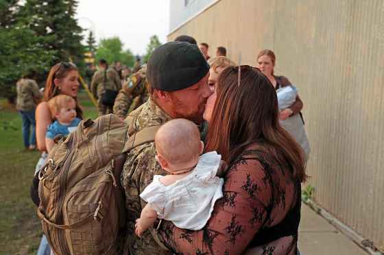 Cpl. Taylor Jackiw kisses his wife, Reagan Chittenden, while reuniting with her and their children Revan and Ivy at CFB Shilo on Tuesday evening. Reynolds was among 150 soldiers returning home from an operation in Latvia. (Tim Smith / The Brandon Sun)