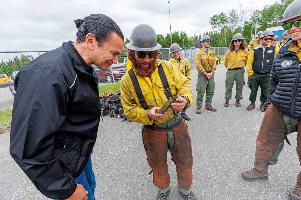 Premier Wab Kinew greets and chats with the Logan Hotshots from the U.S. Forest Service as they get ready to drop into a hot zone for the day.