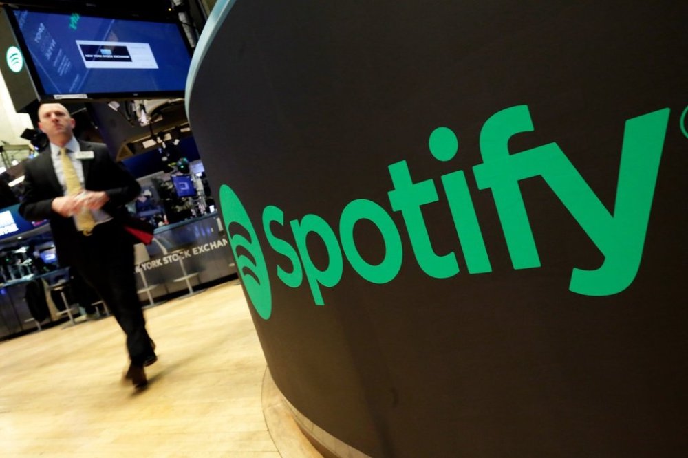 A trading post sports the Spotify logo on the floor of the New York Stock Exchange on Tuesday, April 3, 2018. (AP Photo/Richard Drew, File)