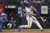 Texas Rangers' Wyatt Langford hits a double that scored teammate Sam Haggerty in front of Kansas City Royals catcher Freddy Fermin during the first inning of a baseball game, Wednesday, June 18, 2025, in Arlington, Texas. (AP Photo/LM Otero)