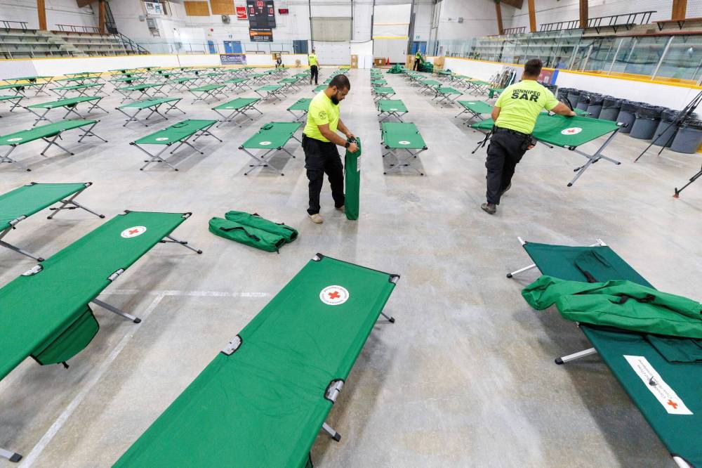 MIKE DEAL / FREE PRESS FILES
                                Winnipeg Search and Rescue volunteers set up roughly 100 cots in the Eric Coy Arena in preparation for wildfire evacuees’ arrival last week.