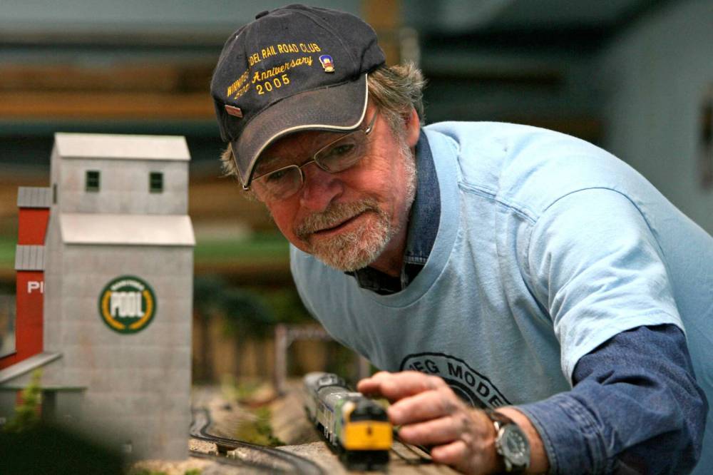 Morgan Turney places an engine on the track of the Winnipeg Model Railway Club Gateway Western Railroad in the basement of Gooch’s. (Mike Deal / Free Press files)