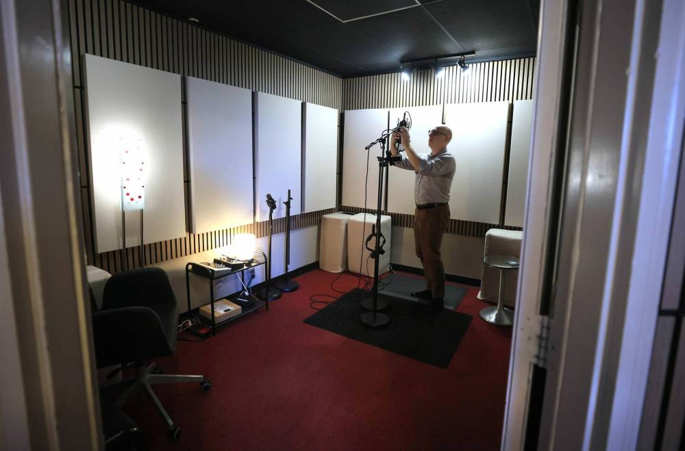 Andrew Yankiwski adjusts a microphone in the recording studio. (Ruth Bonneville / Free Press)