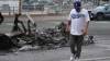 Damian Dovarganes / The Associated Press files
                                A man walks past a burned-out car after a night of protests in downtown Los Angeles on Monday.