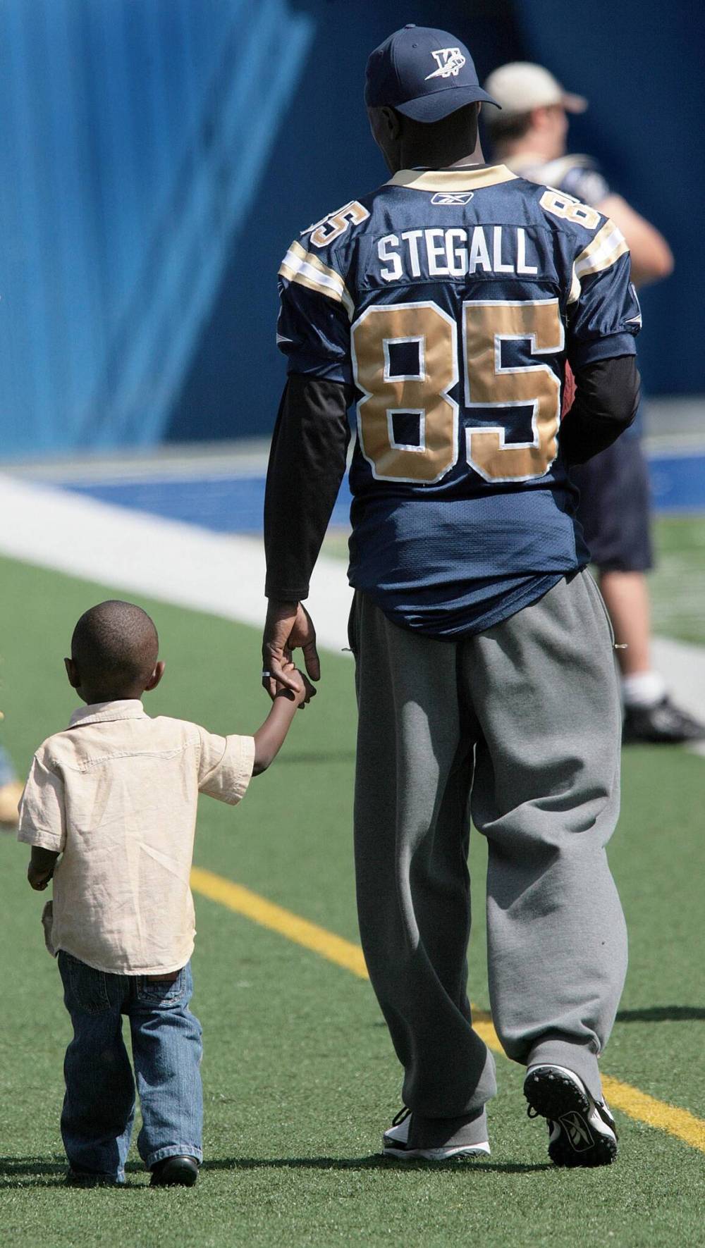 JOE BRYKSA / FREE PRESS FILES
Winnipeg Blue Bombers’ Milt Stegall walks with his son Chase, Milt’s special guest at a Bombers practice in 2007, on the old Canad Inns Stadium field.