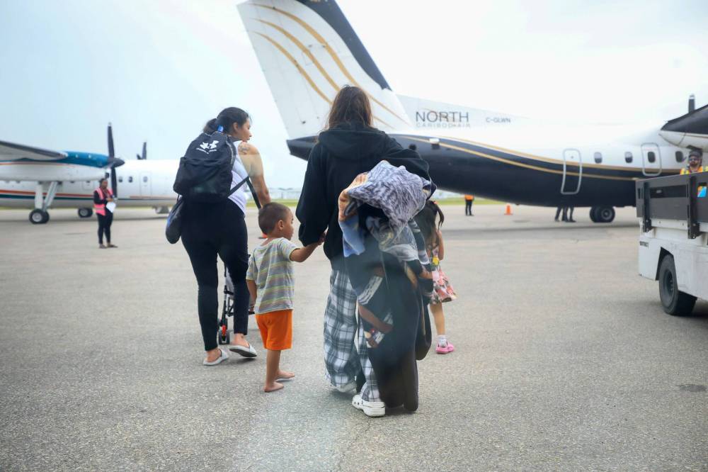 Ruth Bonneville / Free Press
Evacuees from Cross Lake make their way across the tarmac to board a flight home at Perimeter Airlines, Monday.