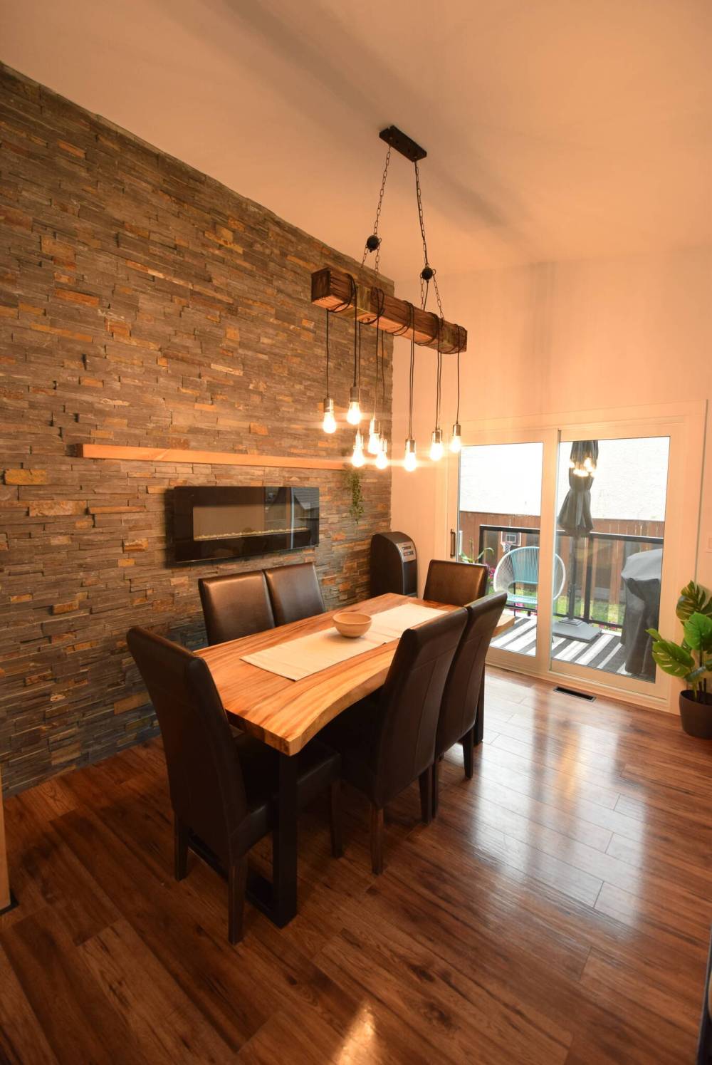 The dining area, which is next to a sliding patio door that leads out to an elevated barbecuing deck in the side yard, is framed perfectly by an elegant cultured stone feature wall.