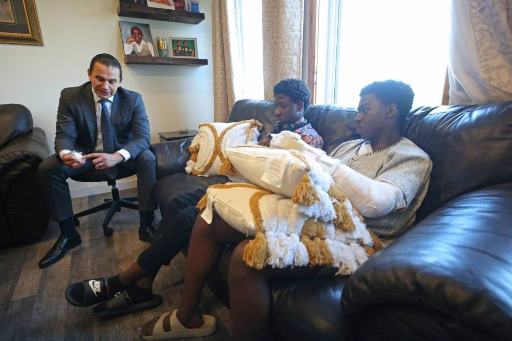 MATT GOERZEN / THE BRANDON SUN
Premier Wab Kinew presents École Secondaire Neelin High School Grade 10 student Chinonso Onuke, right, a Premier’s Challenge Coin, as his twin brother Chiemeka Onuke watches Thursday.