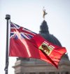 MIKAELA MACKENZIE / WINNIPEG FREE PRESS 	 The Manitoba flag flies in front of the Manitoba Legislative Building on Monday, Aug. 19, 2024. According to a Probe Research poll, 49% of Manitobans would support creating a new flag for the province. Winnipeg Free Press 2024