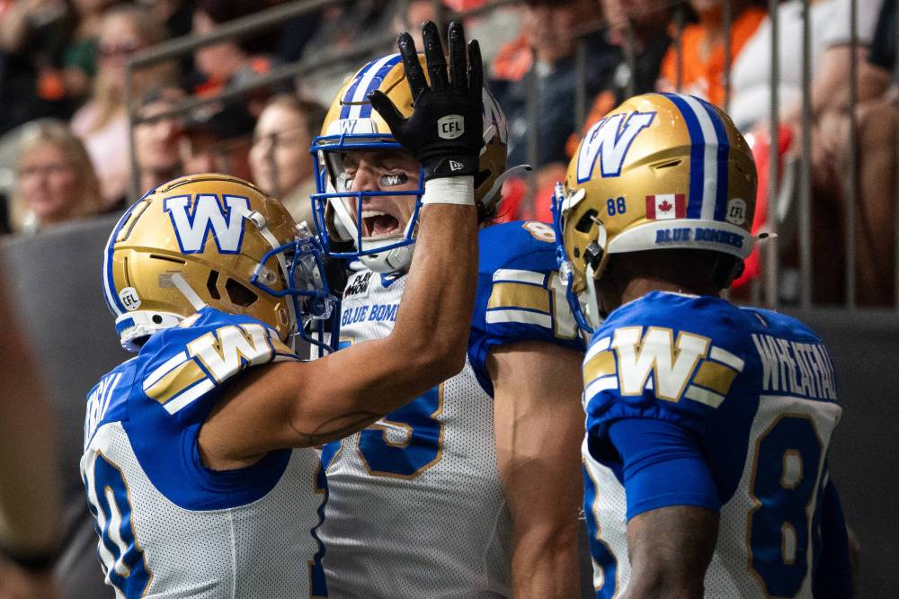 ETHAN CAIRNS / THE CANADIAN PRESS
Winnipeg Blue Bombers’ Dalton Schoen, centre, celebrates scoring a touchdown against the B.C. Lions with Nic Demski, left, and Keric Wheatfall, right, during the first half of a CFL football game in Vancouver, on Saturday, June 21, 2025.