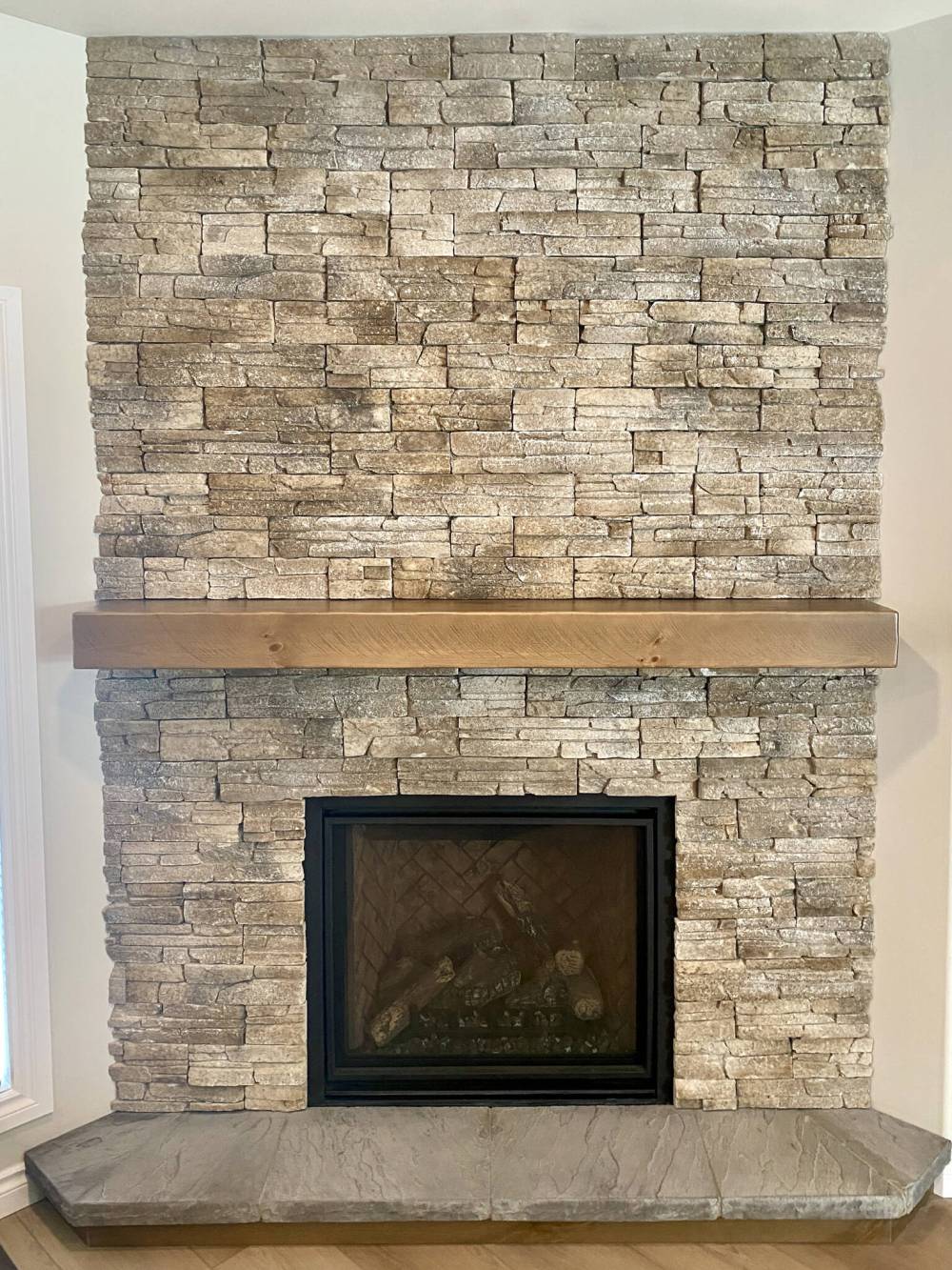 MARC LABOSSIERE PHOTOS / FREE PRESS
Stack stone installed from floor to ceiling enhances the look of the new gas fireplace with its custom stained mantel and flat stone hearth.