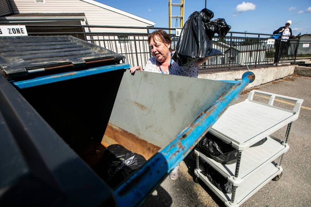 MIKAELA MACKENZIE / FREE PRESS
                                Kathy Benson throws away the contents of her freezer after getting back home.
