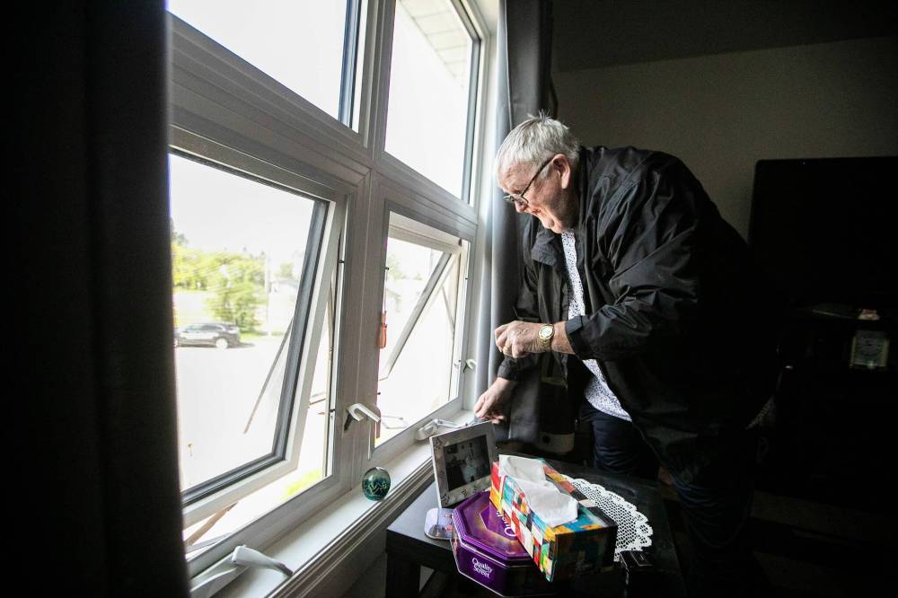 MIKAELA MACKENZIE / FREE PRESS
                                Brian Humphreys opens the window to air out their apartment.