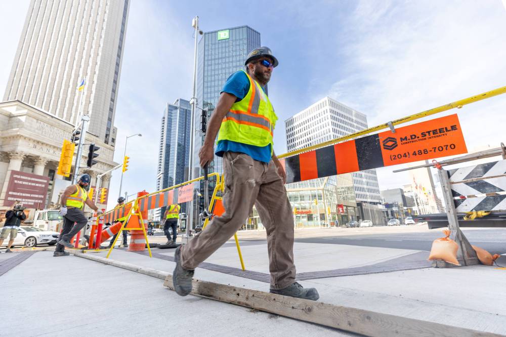 MIKE DEAL / FREE PRESS
Construction crews remove the last of the barriers Friday morning.