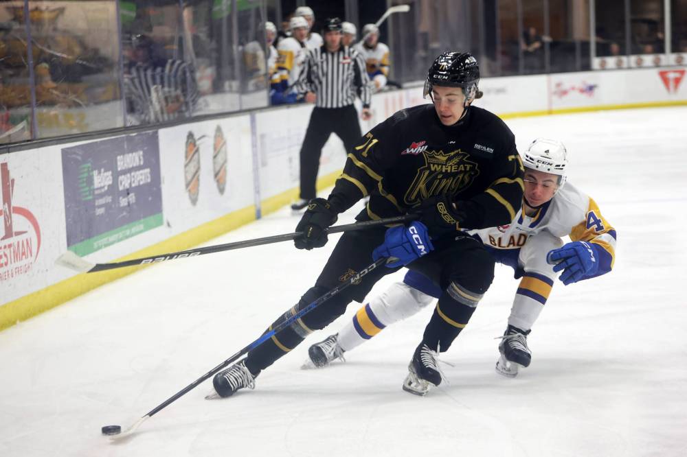 TIM SMITH / THE BRANDON SUN FILES
Brady Turko of the Brandon Wheat Kings tries to keep the puck out of reach of Brayden Klimpke of the Saskatoon Blades during WHL action.