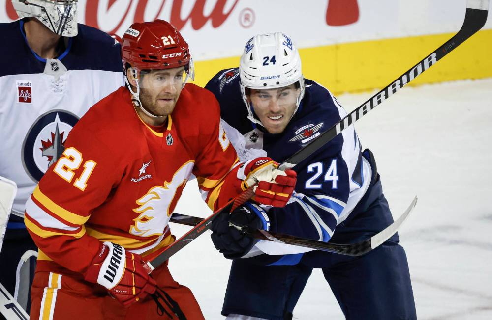 JEFF MCINTOSH / THE CANADIAN PRESS FILES
Winnipeg Jets’ Haydn Fleury, right, checks Calgary Flames’ Kevin Rooney during first period NHL preseason hockey action in Calgary, Alta., in October 2024.