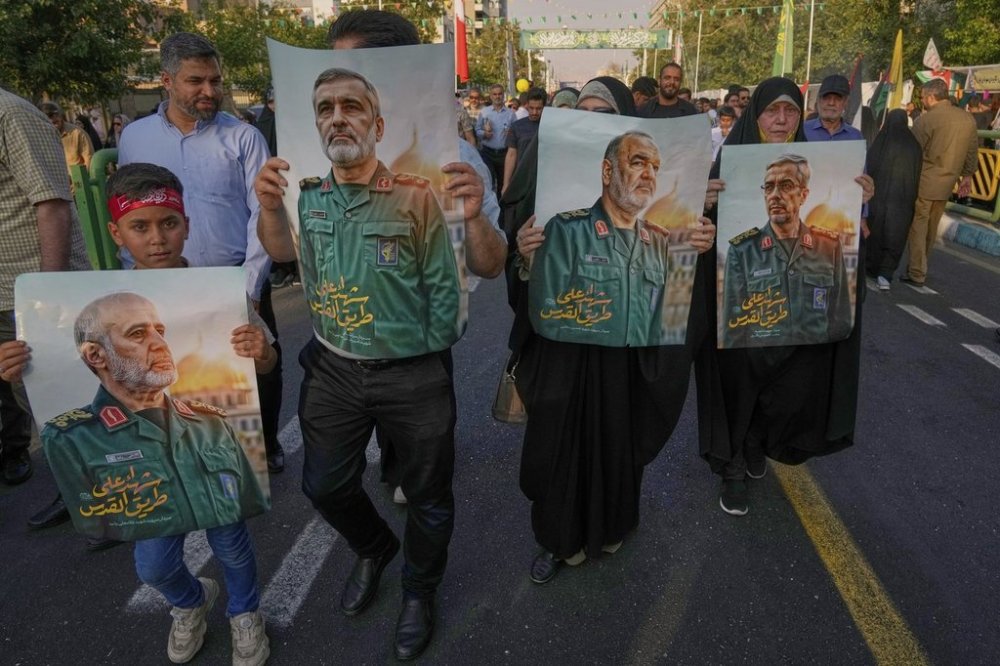 Demonstrators carry posters of top Iranian commanders killed in Friday's Israeli strikes on Tehran, during the Muslim Shiite holiday of Eid al-Ghadir, which commemorates the Prophet Muhammad naming Ali, revered as the first Shiite imam, as his successor, in Tehran, Iran, Saturday, June 14, 2025. (AP Photo/Vahid Salemi)