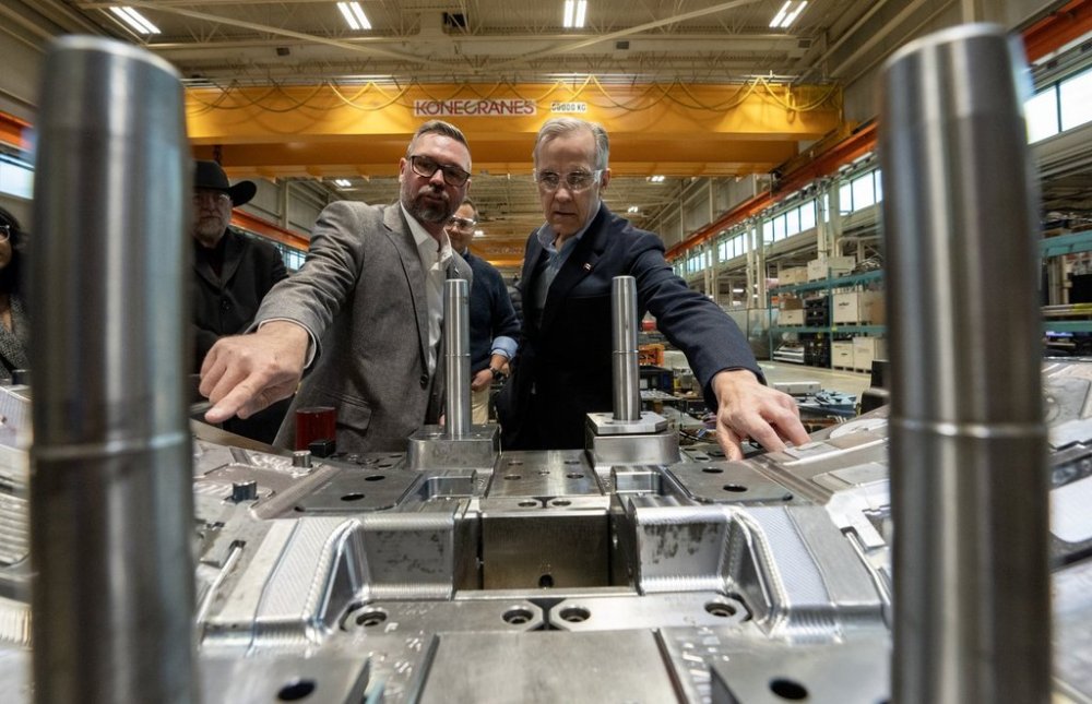 Prime Minister Mark Carney and facility GM Rob Gignac look at an automotive light mould at ABC Windsor in Windsor, Ont., Wednesday, March 26, 2025. THE CANADIAN PRESS/Frank Gunn