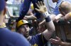 Milwaukee Brewers' Caleb Durbin is greeted in the dugout after hitting a two-run home run against the Chicago Cubs during the second inning of a baseball game Thursday, June 19, 2025, in Chicago. (AP Photo/David Banks)