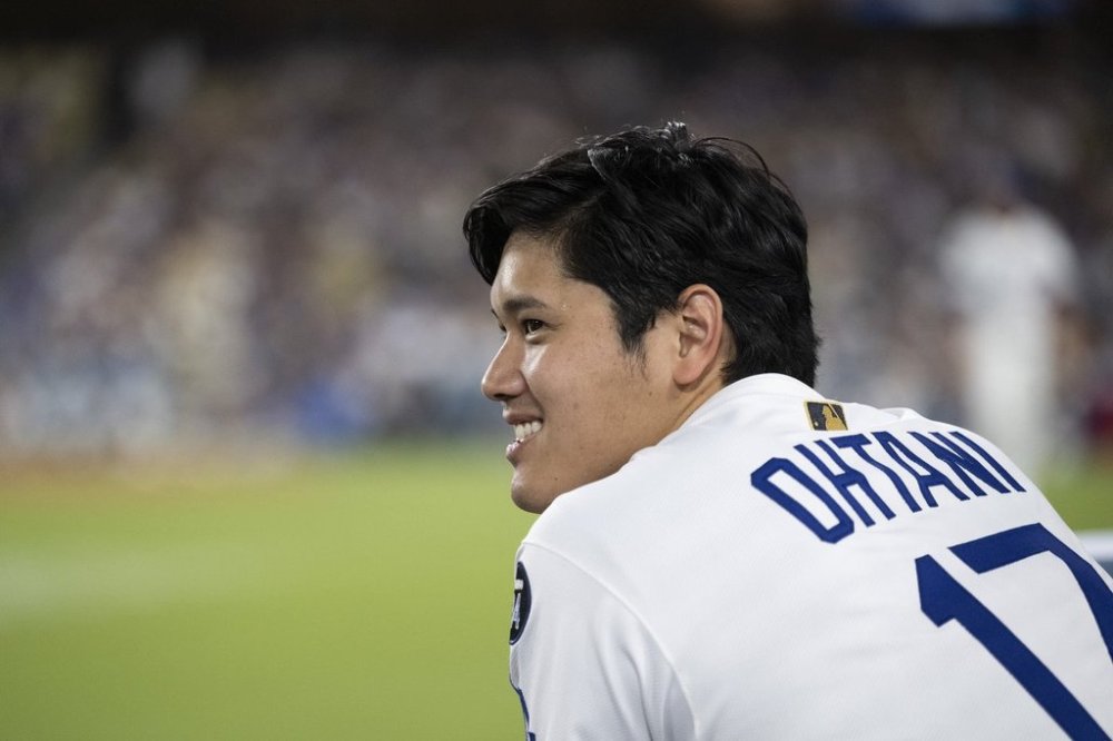 Los Angeles Dodgers' Shohei Ohtani smiles during the seventh inning of a baseball game against the San Diego Padres, in Los Angeles, Tuesday, June 17, 2025. (AP Photo/Kyusung Gong)