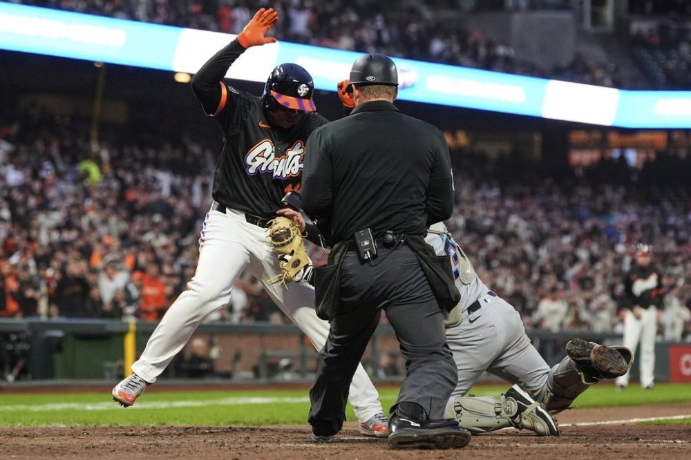 San Francisco Giants' Rafael Devers, left, is tagged out at home by Miami Marlins catcher Liam Hicks, right, during the fifth inning of a baseball game Tuesday, June 24, 2025, in San Francisco. (AP Photo/Godofredo A. Vásquez)