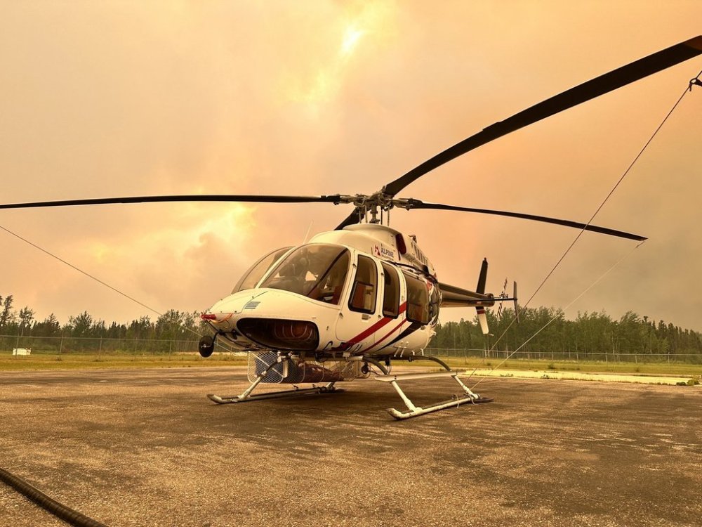 An orange-coloured haze, resulting from a nearby wildfire, is seen on a helipad in La Ronge, Sask., in an undated handout photo. THE CANADIAN PRESS/HO-Saskatchewan Public Safety Agency, *MANDATORY CREDIT*