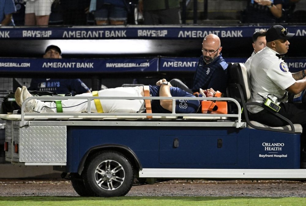 Tampa Bay Rays' Hunter Bigge is taken off the field after being hit by a foul ball while in the dugout during the seventh inning of a baseball game against the Baltimore Orioles, Thursday, June 19, 2025, in Tampa, Fla. (AP Photo/Jason Behnken)