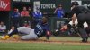 Seattle Mariners' Randy Arozarena (56) scores against Texas Rangers catcher Kyle Higashioka, back right, during the 12th inning of a baseball game, Friday, June 27, 2025, in Arlington, Texas. (AP Photo/LM Otero)