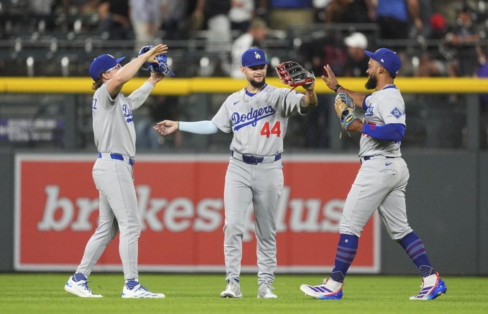 From left, Los Angeles Dodgers left fielder Kike Hernández, center fielder Andy Pages and right fielder Teoscar Hernández celebrate after defeating the Colorado Rockies in a baseball game Tuesday, June 24, 2025, in Denver. (AP Photo/David Zalubowski)