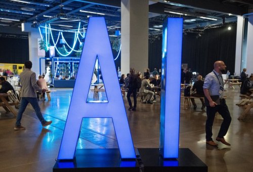 People walk past an AI sign at the All In artificial intelligence conference Thursday, Sept. 28, 2023  in Montreal.THE CANADIAN PRESS/Ryan Remiorz