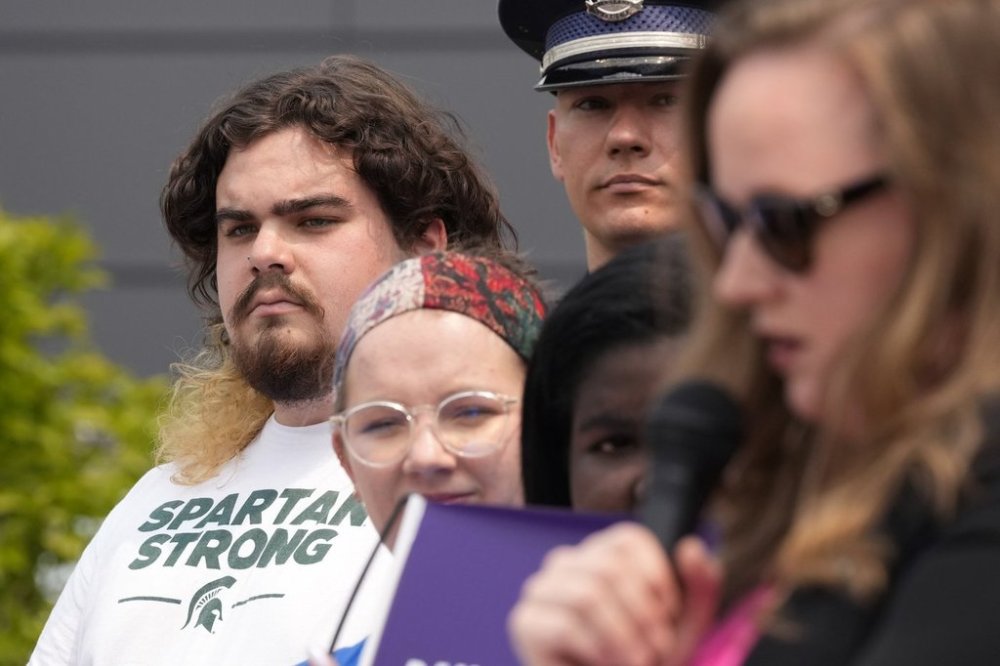 FILE - Michigan State University shooting survivor Troy Forbush, left, listens as State Rep. Kelly Breen, right, speaks, May 22, 2023, in Royal Oak, Mich. (AP Photo/Carlos Osorio, file)