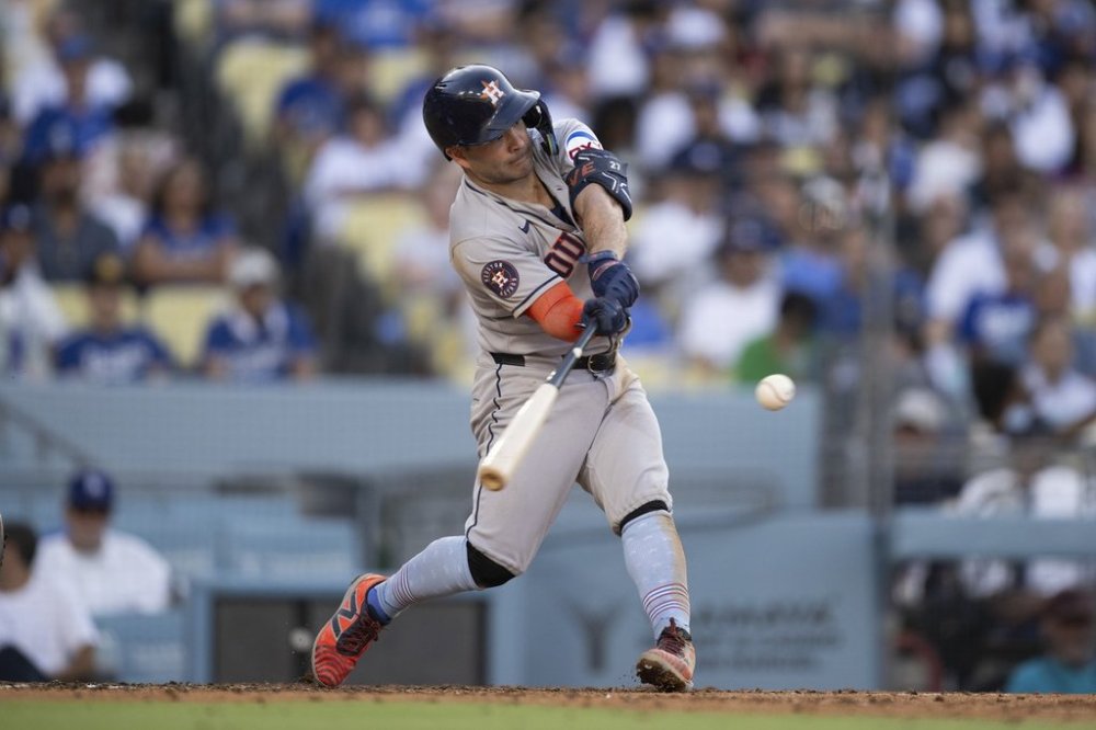 Houston Astros' Jose Altuve hits a two-run home run during the third inning of a baseball game against the Los Angeles Dodgers in Los Angeles, Friday, July 4, 2025. (AP Photo/Kyusung Gong)