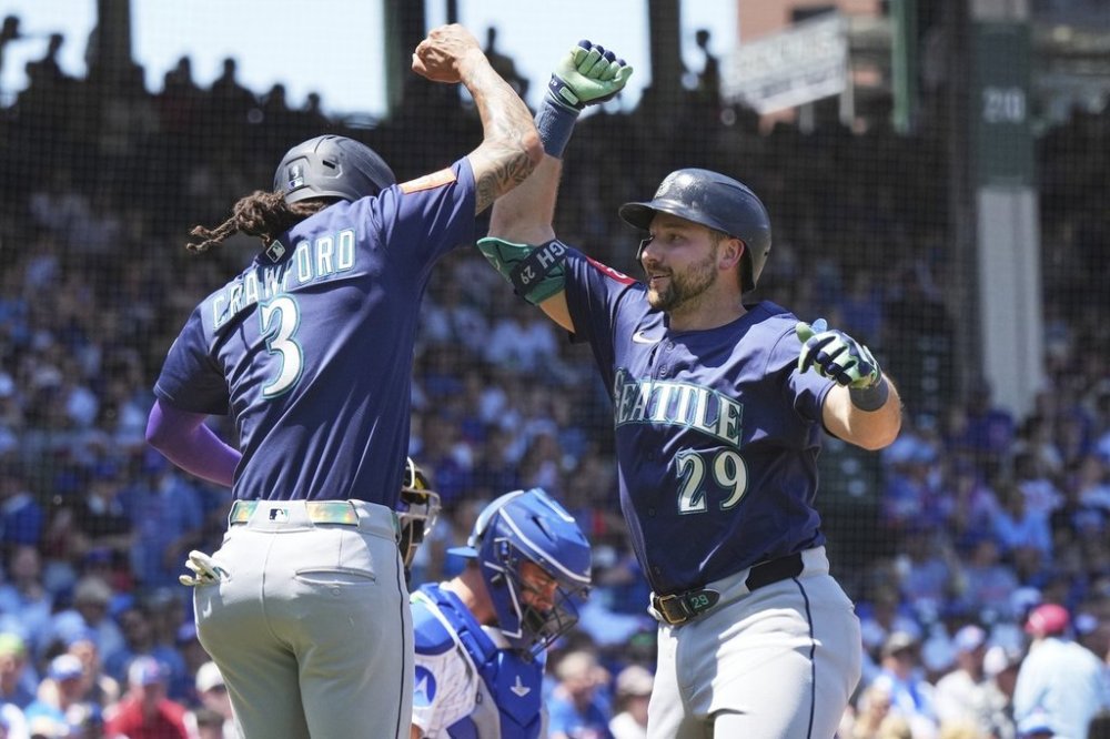 Seattle Mariners' Cal Raleigh, right, celebrates with J.P. Crawford after hitting a two-run home run during the first inning of a baseball game against the Chicago Cubs in Chicago, Sunday, June 22, 2025. (AP Photo/Nam Y. Huh)