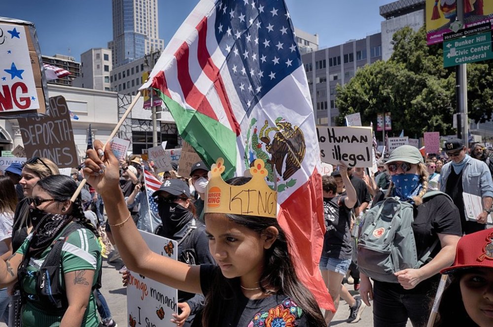 A young protester carries a combination Mexican and U.S. flag during a