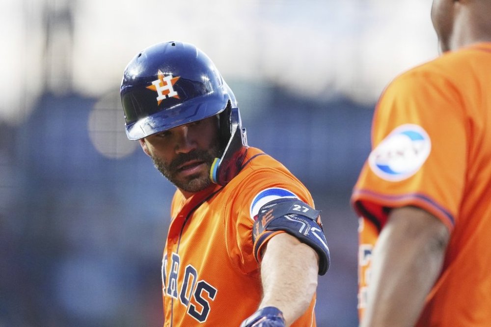 Houston Astros first base coach Dave Clark, right, congratulates Jose Altuve after his single to drive in two runs off Colorado Rockies relief pitcher Jake Bird in the sixth inning of a baseball game Wednesday, July 2, 2025, in Denver. (AP Photo/David Zalubowski)