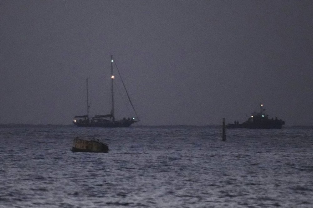 The Gaza-bound aid boat, Madleen, left, under escort of Israeli naval forces making its way toward Ashdod Port in southern Israel after being seized by Israeli forces, Monday, June 9, 2025. (AP Photo/Leo Correa)